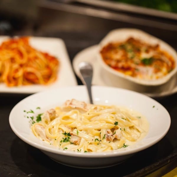 Creamy fettuccine alfredo with chicken and parsley, alongside other Italian pasta dishes.